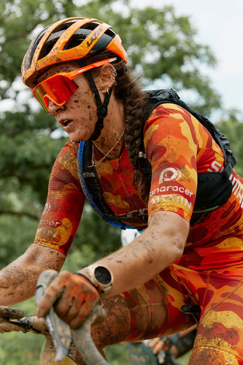 Girl in orange cycling gear wearing a camelbak chase race